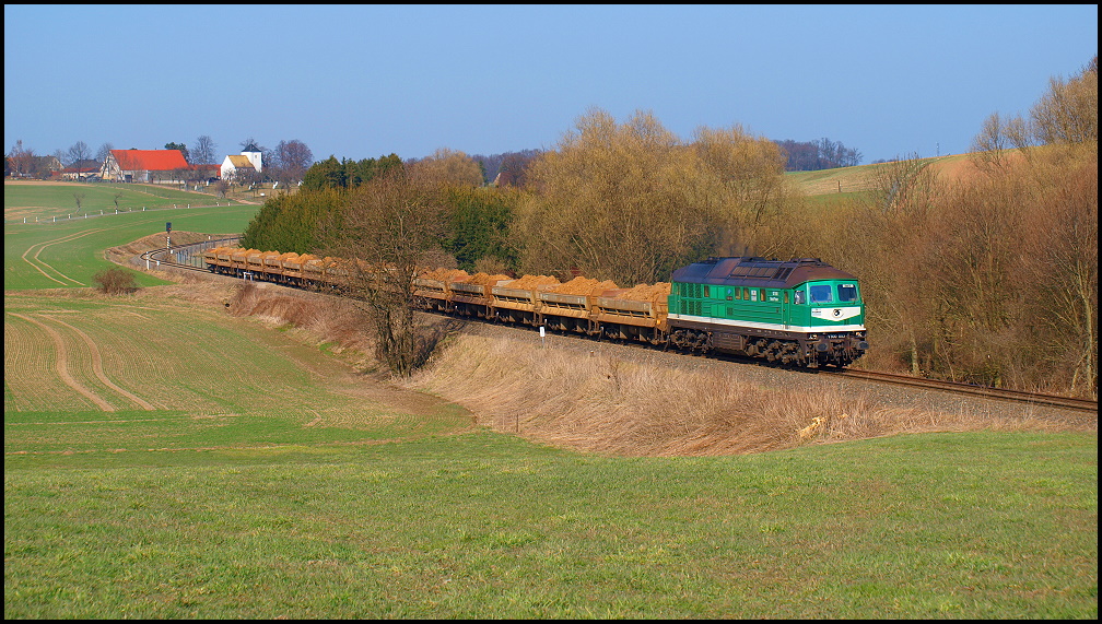 Am 29.03.2011 schleppt V300 003 (wie BR 232) den Sandzug von den Gruben bei Kayna in das Bergbau-Sanierungsgebiet rund um Ronneburg, hier beim Ort Frankenau mit seinem kleinen Kirchlein.