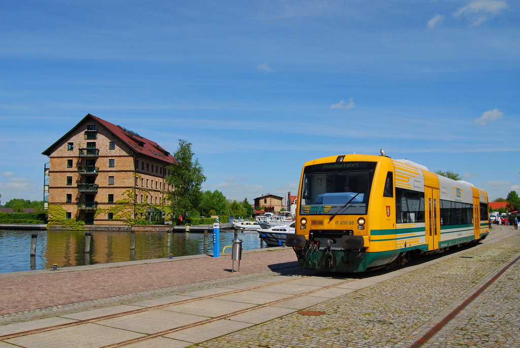 Am 29.05.2010 fand anl�sslich des Hafenfestes am Zierker See in Neustrelitz eine Sonderfahrt der ODEG statt. Hier f�hrt der der ODEG Triebwagen VT 650.88 gerade durch den Speicherbereich des Hafens. Heute finden sich hier �berwiegend teure Wohnungen in den alten Speichergeb�uden. 