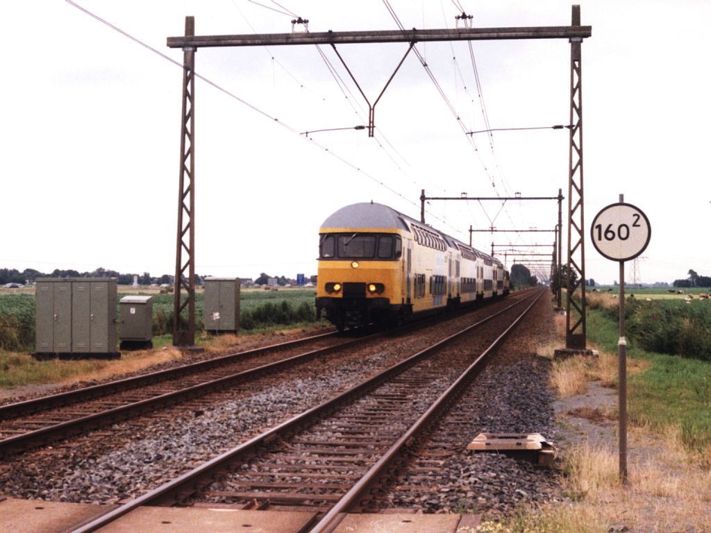 Am 4-7-1998 ist die Besichtigungstag der Flughaven Leeuwarden und gibt es mehr Abwechselung zwischen Zwolle und Leeuwarden. Hier ist Doppelstockwagen 7432 und E-lok 1725 unterwegs bei Wirdum als Sonderzug Zwolle-Leeuwarden. Bild und scan:Date Jan de Vries.