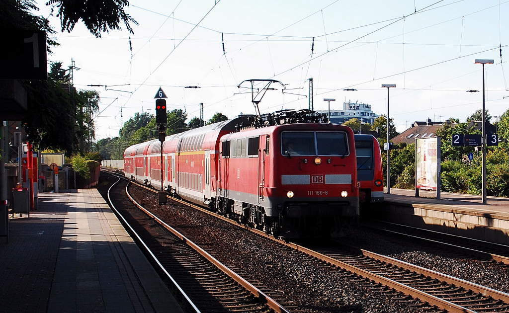 Am Abend des 1.7. 2012 fhrt mit hoher Geschwindigkeit die 111 160-8 mit einem RE7 durch Neuss-Norf in Richtung Kln.