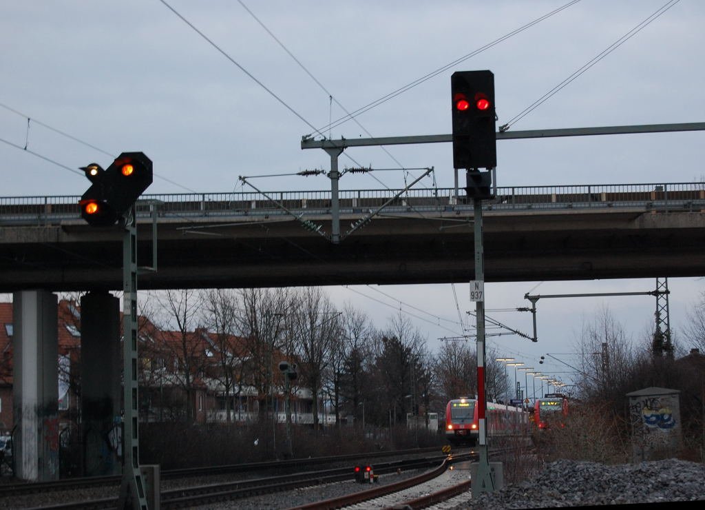 Am Abend des 20.3.2010 entstand diese Foto, das Tageslicht ging zur Neige und die knstlichen Lichter erhellten die Umgebung. Dadurch kommen die Lichtsignale schn zur Geltung. Im Hintergrund erkennt man zwei S-Bahntriebzge der Linie S8 am erleuchteten Bahnsteig.