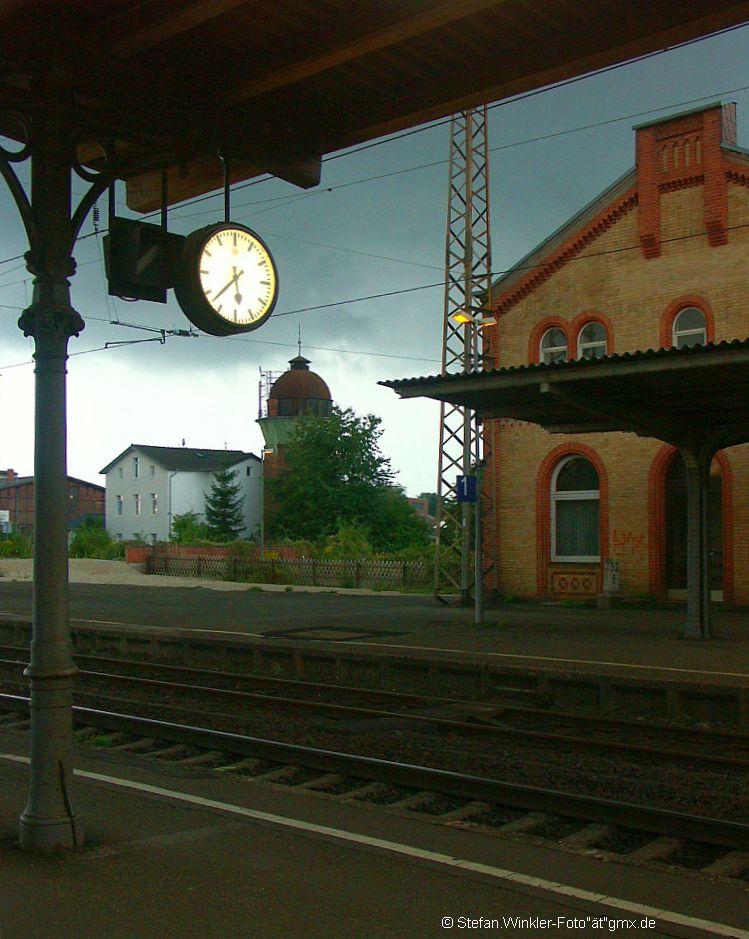 Am Ende kommt mein persnlicher Favorit der Elze-Bilder: Whrend des Unwetters schaltete sich mal fr 5 Min die komplette Beleuchtung ein, weil es so dunkel wurde an dem Abend des 12.09.2010. Hier kommt der Blick vom Mittelbahnsteig mit Uhr auf den Wasserturm in der vormals Graafschen Waggonfabrik hinter dem Bahnhof (heute VTG), wo noch heute Waggons gewartet und gebaut werden. Rechts der linke Flgel des EG mit dem Dach am Hausbahnsteig.