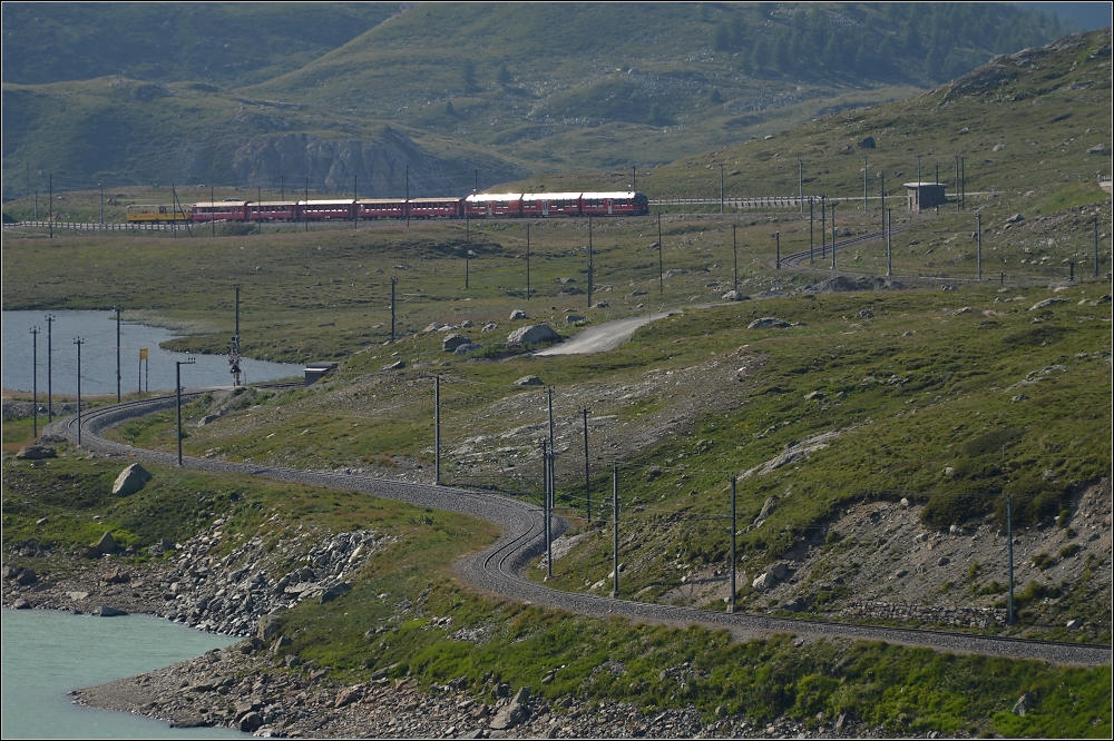 Am Lago Bianco (III).

Mit Untersttzung der Sonne hebt sich der Zug deutlich vom  Talgrund  ab und kndigt sich schon einige Minuten vor der Vorbeifahrt an. Das Kraftpaket Allegra an der Zugspitze leuchtet dabei standesgem am hellsten. Im Juli 2013