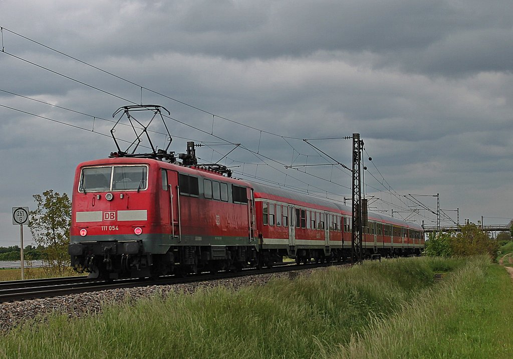 Am Mittag des 23.05.2013 schob die Freiburger 111 054 eine RB von Neuenburg (Baden) nach Offenburg. Hier ist der Regio kurz hinter Mllheim (Baden) bei Hgelheim.