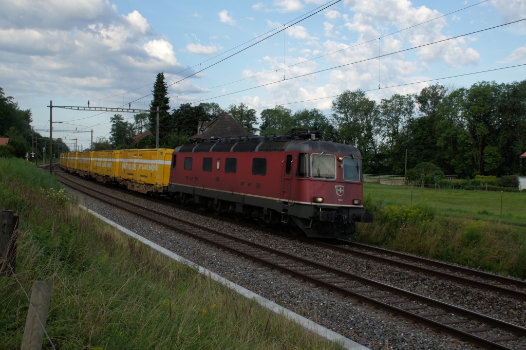 Am Morgen des 19.7.12 zieht die Re 6/6 11641 einen Postzug von Lyss Richtung Biel, hier bei Busswil.