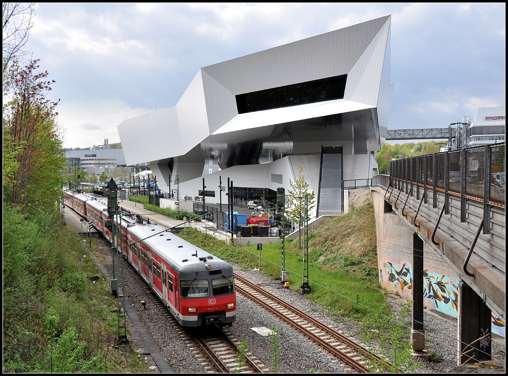 Am Museum - 

Ein Triebzug der Baureihe 420 verlässt die Station Neuwirtshaus (Porscheplatz) in Stuttgart-Zuffenhausen. Daneben das markante Porschemuseum. 

13.04.2011 (J)