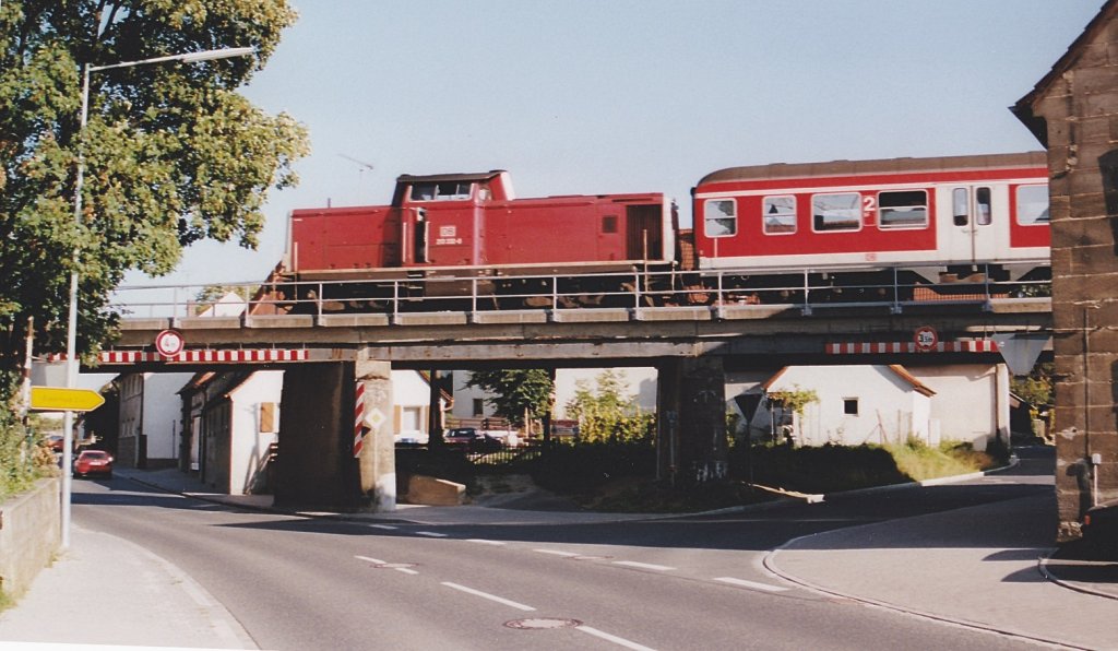 Am nrdlichen Ortsrand von Forth berquert die Bahnlinie die Bundesstrae B2 auf einer Brcke. Der Blick nach Osten am 11.8.00 zeigt 212 332 an der Zugspitze.
