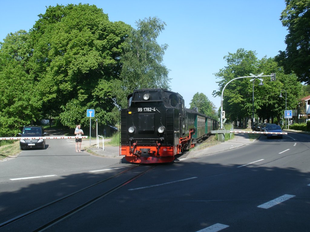 Am Ortsein-und ausgang von Binz befindet sich Dieser Bahn�bergang.Am 28.Mai 2012 passierte 99 1782 mit dem P 223 nach G�hren den Bahn�bergang.