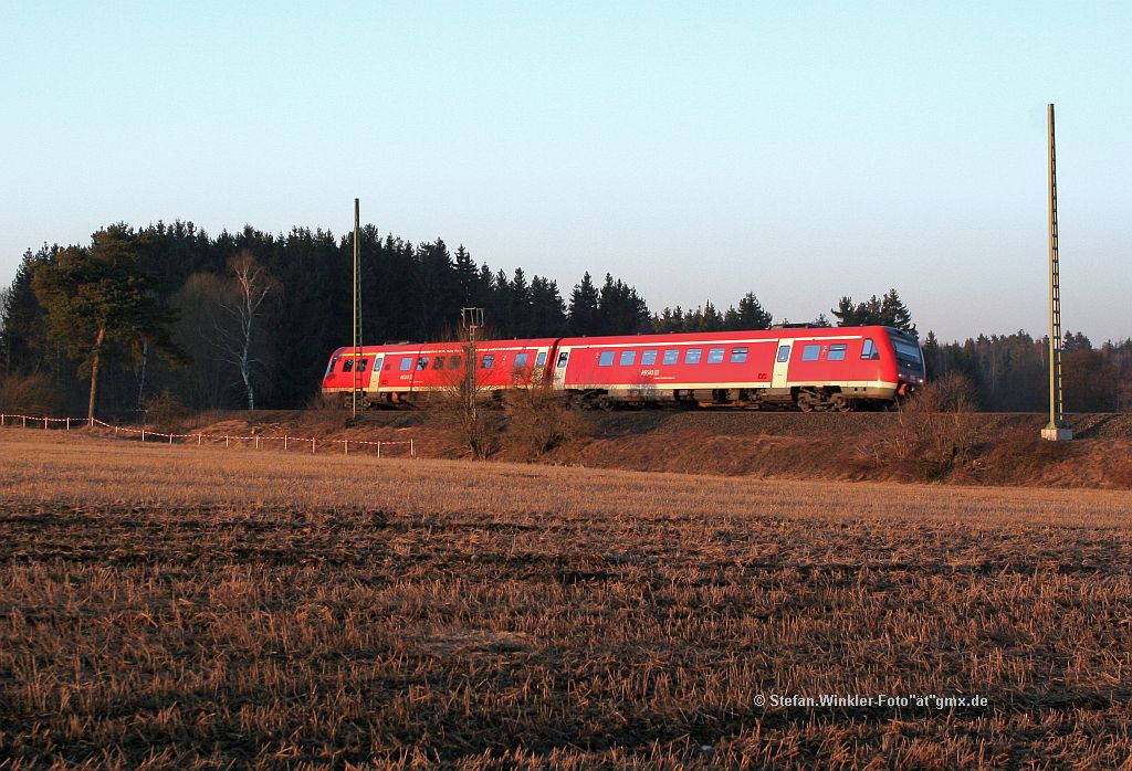 Am spten Nachmittag kommt dieser 612 mit aktiver NT von Gutenfrst ri Hof herber und wird bald an den paar Husern des Drfchens Fhrig in Nordbayern vorbeifahren. Die Sonne steht schon sehr tief an diesem 2.Mrz 2011, die Oberleitungsmasten sind erst einige Tage dort...