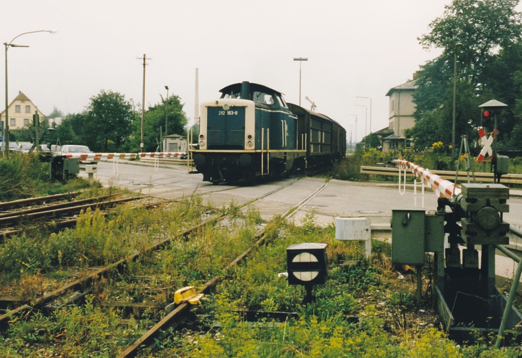 Am sdlichen Ende des Feuchtwanger Bahnhofs liegt der Bahnbergang der Bundesstrae B 25. Im Sommer 1987 wurden die Schranken noch vom rtlichen Fahrdienstleiter herauf- und heruntergekurbelt. Anschlieend stellte er das Ausfahrsignal, dasman hinter der Lok sehen kann, auf Fahrt.