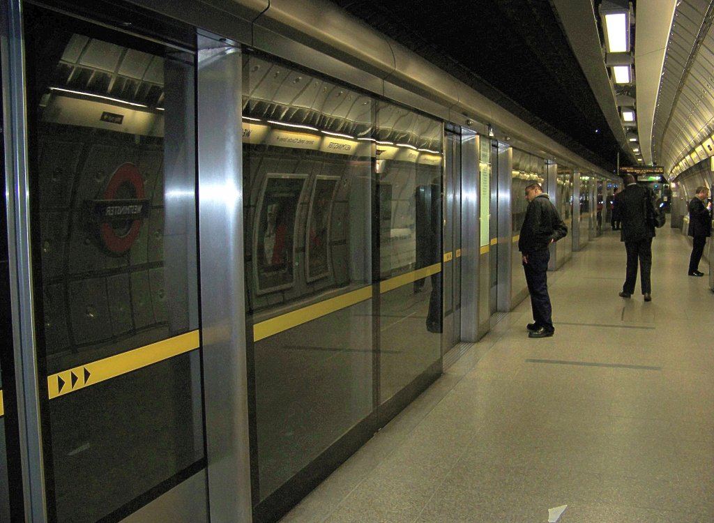 An der futuristischen Westminster Station (Gelegen an der Central Line, der District Line und der Jubilee Line) sind einige Bahnsteige (die der Jubilee) mit Glasw�nden zum Gleis hin gesichert. Die Herausforderung f�r die Tf's ist dann jedes Mal, so punktgenau zu halten, dass die zugt�ren mit denen am Bahnsteig �bereinstimmen. Aufgenommen am 17.3.010.
