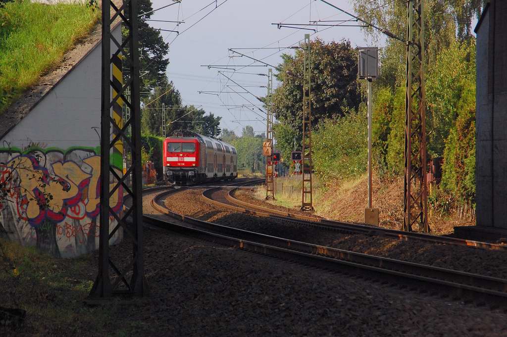 An der Kbs 495 �berf�hrung der U79 hatte ich am Sonntagsp�tnachmittag diesen Durchblick auf die 112 136 mit einem RE7 Zug der aus Krefeld kommend durch Osterath f�hrt. Hier �berquwert sie geraden den B� G�rgesheideweg 2.9.2012