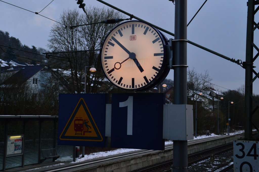 Analoge Bahnhofsuhr in Neckargerach, wenigstens etwas erinnert noch an die gute alte Zeit bei der Eisenbahn, als die meisten Zge auch noch pnktlich fuhren....9.2.2013.....ach ja, ich weiss nicht wie genau es zu erkennen ist, aber auf den Glas spiegelt sich das Gitter der Fugngerbrcke.