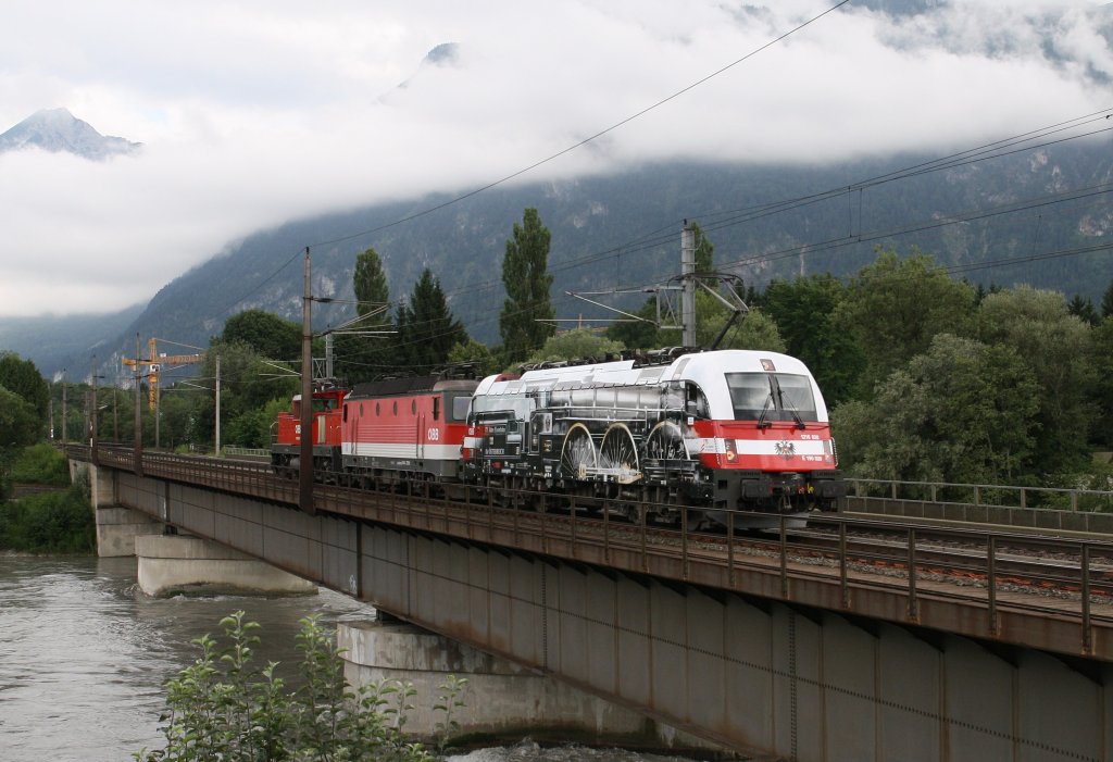 Anlsslich der 175 Jahre Eisenbahn in sterreich wurde die 1216 020-8 als Dampftaurus beklebt. Symbolisieren soll sie die Rh 310 aus dem Jahr 1911. Hier fhrt sie am 11.7.2012 mit 1144 270-6 und 1063 039-0 von Innsbruck nach Wrgl ber die Innbrcke vor Brixlegg.