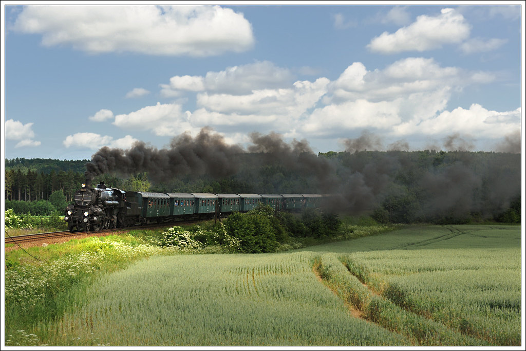 Anlässlich des k&k Dampfloktreffens im  Eisenbahnmuseum Lu¸ná u Rakovníka bespannte am 22.6.2013 die Strasshofer 310.23 einen Sonderzug von Praha hlavní nádra¸í nach Lu¸ná u Rakovníka. Die Aufnahme zeigt den Zug kurz nach der Ausfahrt aus Nové Stra¨ecí mit der sprichwörtlichen Shitongwolke.

