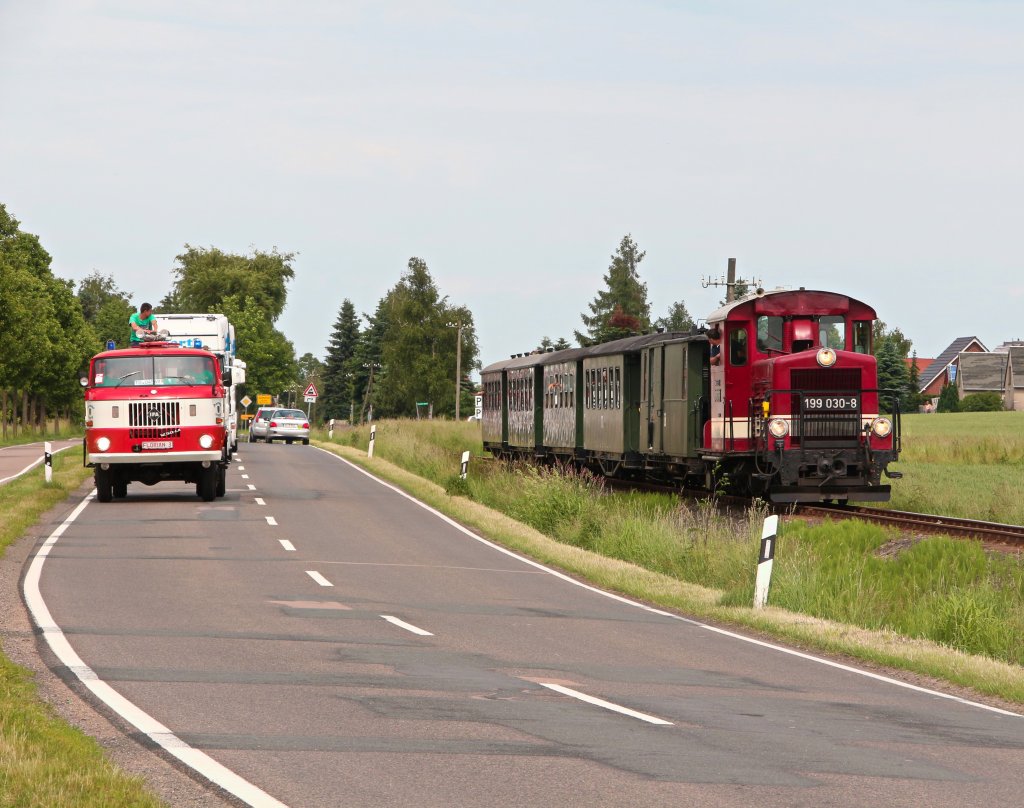 Anlsslich des Oschatzer Trucker-Treffens fand eine Parallelfahrt mit der Dllnitzbahn und den teilnehmenden LKW's statt. Hier ist die Kollonne zwischen Schweta und Mgeln zu sehen. 15.06.2013