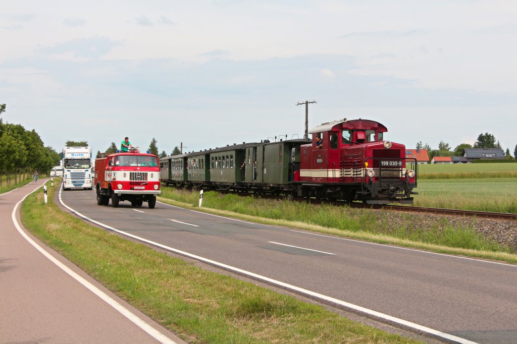 Anlsslich des Oschatzer Trucker-Treffens fand eine Parallelfahrt mit der Dllnitzbahn und den teilnehmenden LKW's statt. Hier ist die Kollonne zwischen Schweta und Mgeln zu sehen. 15.06.2013