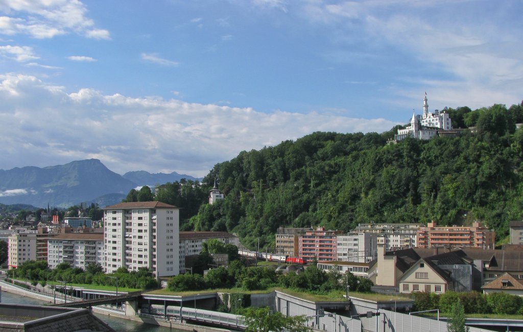 Anschliessend an den Gtschtunnel fhrt der von einer Re 460 gezogene IR 2326 (Luzern-Zrich HB) einige Meter ber dem Strassenniveau entlang der multikulturellen Baselstrasse durch die Huser Luzerns. 
5. August 2012
