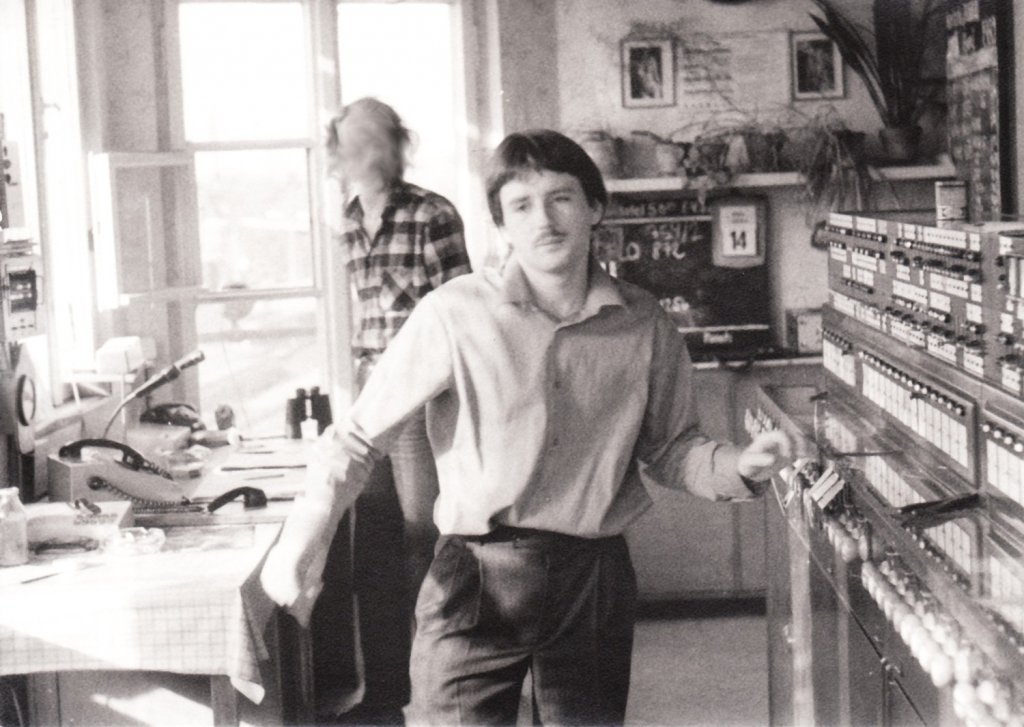 April 1989 Berlin-Buch, Stellwerk  Bu . Mein 200. Bild zeigt mich als  frischen  Fdl in Aktion. Smtliche Weichenhebel im Vordergrund sind mittlerweile entfernt, da Buch Fernbahn mit dem Anschluss ans Estw komplett wegrationalisiert wurde. Den Schnauzer gibts auch nicht mehr und die Haare werden langsam grau. Kollege im Hintergrund digital verfremdet. Eins von den  nur-so-mal  Fotos, die dann irgendwann historisch werden...