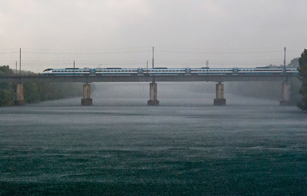 Aprilwetter im Mai. Es schttet bereits, als wenige Minuten spter EC 72  Smetana  die neue Donau berquert. Wien, am 07.05.2010.