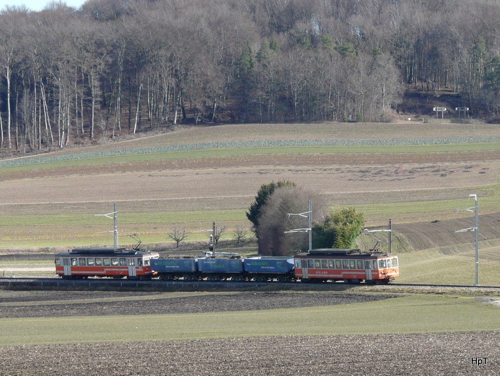 asm BTI - Kieszug mit Be 4/4 523 und 3 Kieswagen Typ Fa und Be 4/4 101 unterwegs bei Siselen am 21.02.2010