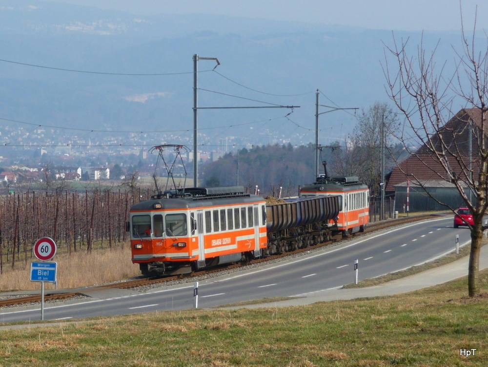 asm Seeland - Kieszug mit den Be 4/4 302 mit 3 Kieswagen sowie der Be 4/4 101 am Schluss zwischen Mrigen und Gerolfingen am 07.03.2012