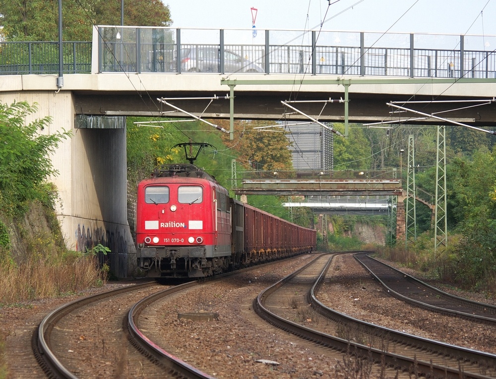 Auch die Baureihe 151 ist im Jahr 2011 noch sehr aktiv...

Damit die Gterzge aus Saarbrcker Rangierbahnhof Richtung Forbach, Vlklingen - Dillingen - Trier und zum Gterbahnhof Malstatt (Saarstahl Burbach) nicht durch den Hauptbahnhof fahren mssen , hat man eine Gterzugumfahrung angelegt.
151 070-0 nutzt ebenfalls die Umfahrung um mit ihrem Gterzug auf die Saartalstrecke zu gelangen.

Noch ein paar kurze Bemerkungen zu den 3 Brcken im Bild. Die Brcke hinten ist die alte Zufahrt zum Bereich des ehemaligen Bw Saarbrcken, dem Wartungsdepot des Regionalbus Saar Westpfalz und danach die Zufahrt zum Europabahnhof von Hinten und zu den dortigen neuen Ansiedlungen.

Die Fugngerbrcke in der Mitte ist die alte Fugngerverbindung vom Stadtteil Rodenhof zum Vorfeld des Hauptbahnhofes und der ehemaligen Hauptpost in Saarbrcken. Das Gleisfeld des Hauptbahnhofes wird durch den Ltzelbachtunnel (Fugngertunnel) unterquert.

Die neue Brcke im Vordergrund wurde im Jahr 2011 fertig gestellt und im Sommer fr den Verkehr frei gegeben und ist eine weitere Anbindung zum Bereich des ehemaligen Bahnbetriebswerkes, wo neue Gewerbeansiedlungen und Dienstleistungszentren im Entstehen sind.

26.09.2011