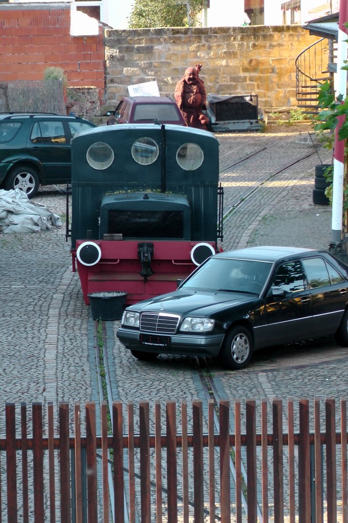Auch ohne den Daimler im Vordergrund knnte diese Kleinlok sich nur wenige Meter bewegen, denn das Gleis endet am Tor.
Aufgenommen vom Interimsbahnsteig der S Bahn in Radebeul West am  16.09.12 gegen 08:54 Uhr, auf die S-Bahn wartend.