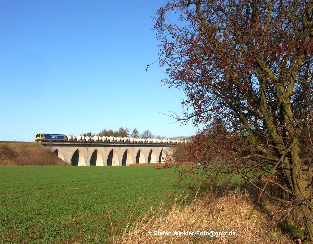 Auch das ist der Sptherbst 2009: Am sonnigen 25.11.2009 bringt die Maxima 264008 den Zementzug der MEG bers Vogtland nach Bayern mit Ziel Regensburg. Hier auf dem Saaleviadukt in Hof-Unterkotzau.