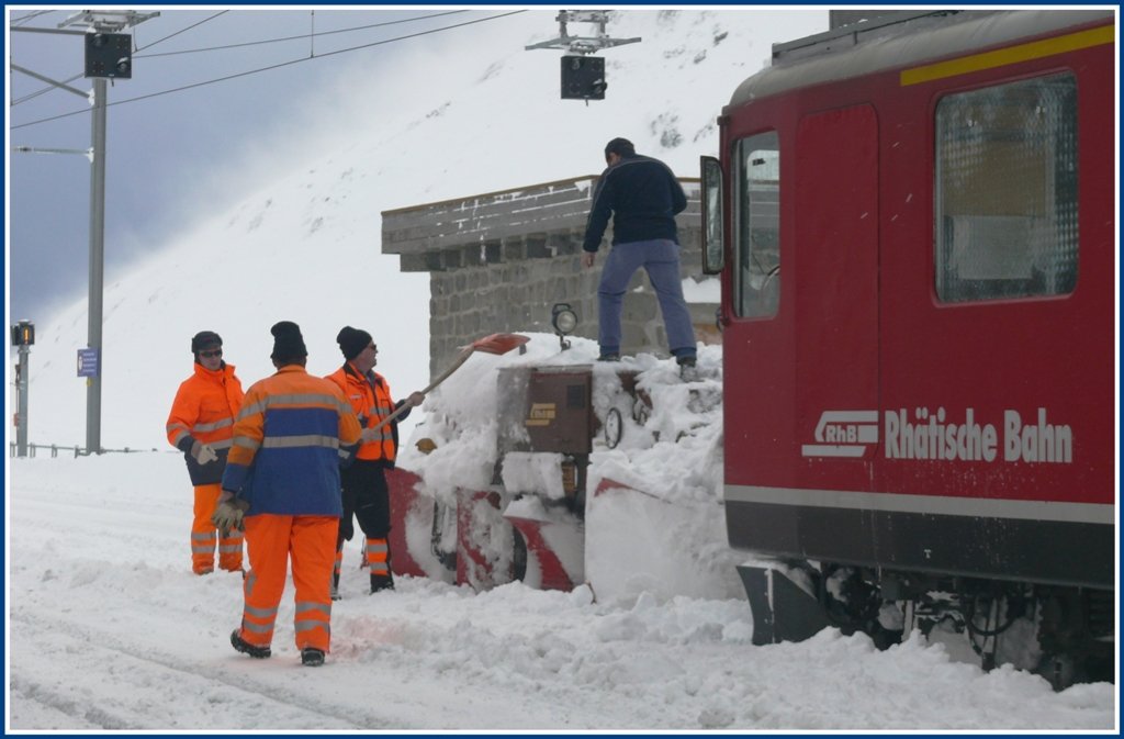 Auch der Spurpflug muss mit Muskelkraft wieder flott gemacht werden. Der Grund der Schneeverwehungen sind die orkanartigen Strme hier oben, die im Hintergrund an der Bergflanke schn zu sehen sind. Und es ist saukalt in Ospizio Bernina und das Restaurant ist auch geschlossen brrr...(01.12.2009)