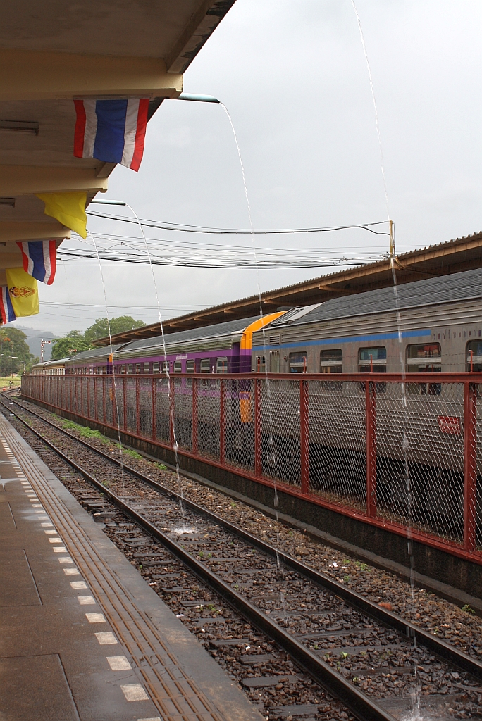 Auch wenn der Regen schon 5 Minuten zu Ende ist, kommt noch immer aufgestautes Wasser vom Bahnsteig-Flachdach. Bf. Surat Thani am 17.Mai 2013. 

