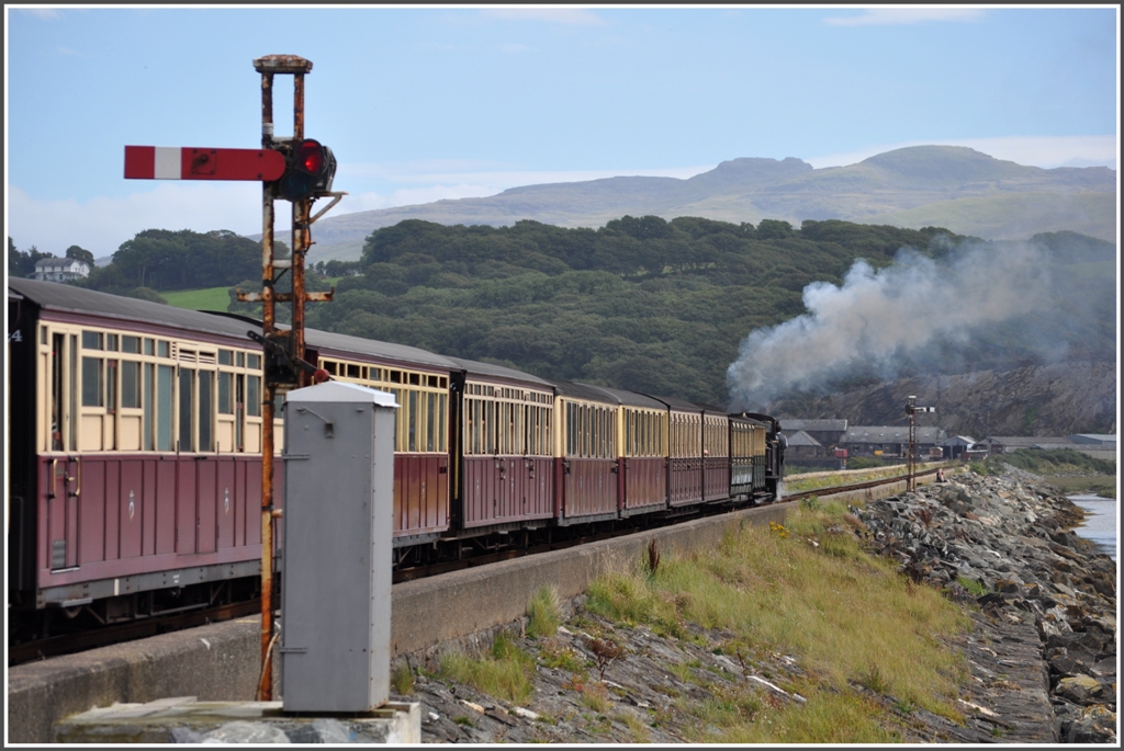 Auf dem Damm, genannt Cob, zwischen Porthmadog und dem Depot Boston Lodge passiert der 13.34 nach Blaenau Ffestiniog das Aus- und Einfahrsignal von Porthmadog. (04.09.2012)