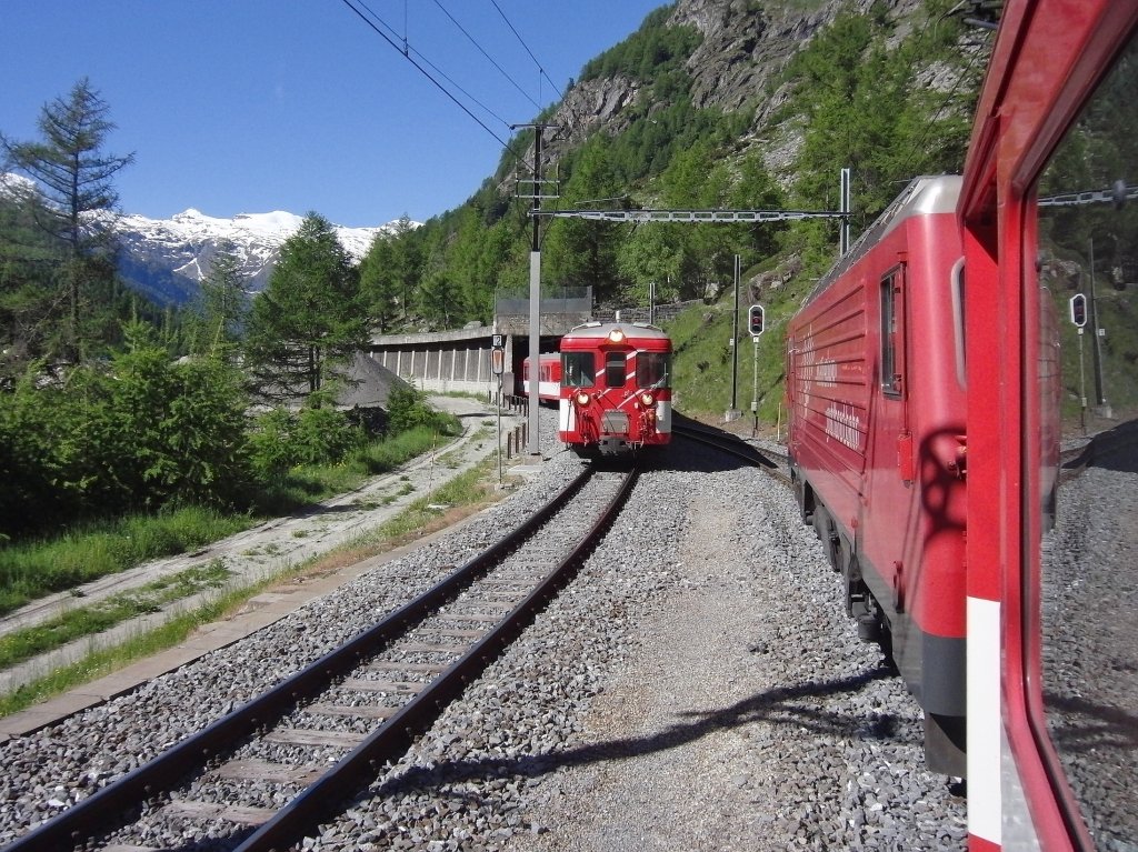 Auf der einspurigen Strecke von Visp nach Zermatt lsst die HGe 4/4 „Mount Fuji“ der Matterhorn Gotthard Bahn an der letzten Kreuzungsstelle vor Zermatt den gerade dort gestarteten RegionalExpress vorbeifahren (16.06.2013).