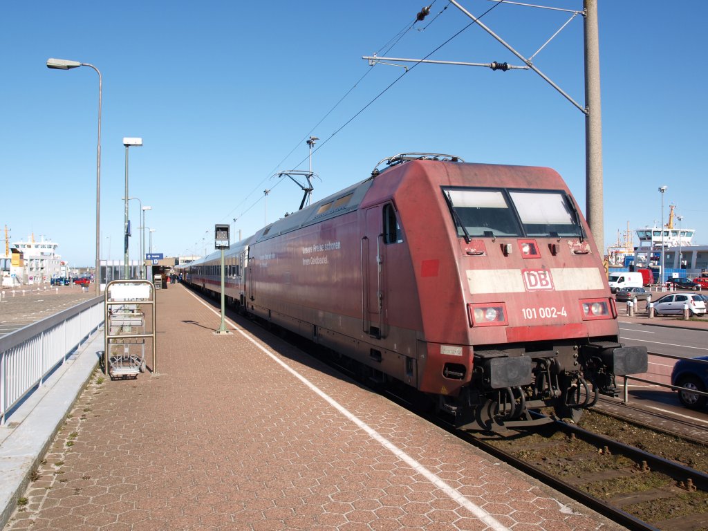 Auf die Reisenden der Nordseeinseln Juist und Norderney und die Abfahrt wartet die noch im originalen Orientrot anzutreffende 101 002 am 19.03.11 mit ihrem IC 132 nach K�ln Hbf in Norddeich Mole. Deutlich ist der direkte Vergleich mit der verkehrsroten Lackierung an der kleinen ausgebesserten Stelle an der vorderen S�ule der Lok zu erkennen. Fragt sich nur, wie lange uns die letzte ihrer Art in Vorserienlackierung noch erhalten bleiben wird: Das �u�ere der Lok wirkt schon ziemlich heruntergekommen...
