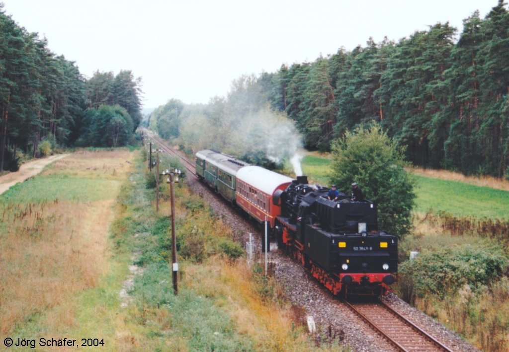 Auf der Rckfahrt nach Nrnberg fuhr der Dampfsonderzug mit dem „Tender voraus“. Westlich von Langlau wurde er kurz vor der Brcke der Staatsstrae 2222 ber die Gleise abgelichtet. (Blick nach Westen am 3.10.99 bei km 43)