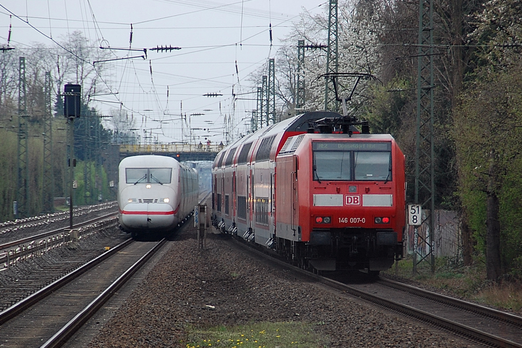 Auf S-Bahngleisen begegnen sich der ICE 402 019-4 Hagen und die 146 007-0 wegen einer Gleisbaustelle an einem Fernbahngleis kurz vorm/hinterm Bahnsteig in Angermund am 3.April 2011.