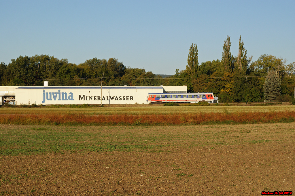 Auf seiner Fahrt als R7724 nach Wiener Neustadt Hbf, passiert ein Triebwagen der Rh 5047 die Abfllanlage eines bekannten Mineralwasserabfllers. Deutschkreutz, 06.10.2012