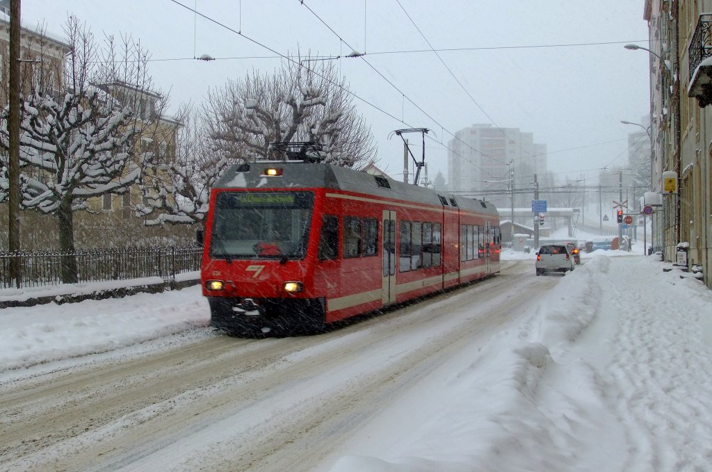 Auf den Strassenbahnschienen, die sich irgendwo unter dem Schnee verbergen, fhrt der CJ-GTW ABe 2/6 634 am 27.11.2010 durch die Rue du Crt Richtung SBB-Bahnhof La Chaux-de-Fonds. 