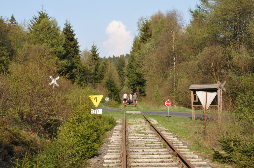 Auf der Strecke zwischen Kalterherberg und Sourbrodt kreuzen die Gleise dreimal eine Strasse. Auch hier stehen die Andreaskreuze noch, jedoch m�ssen die  Railbiker  Vorfahrt gew�hren, worauf das Stopschild hinweist. Zu erkennen hier das  Railbike , das in einigen Metern Abstand vor uns die Abfahrt zur�ck nach Kalterherberg befuhr. Aufgenommen am 24/04/2011. 