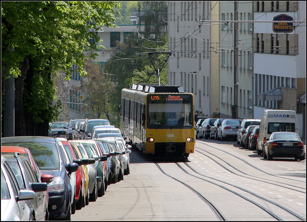 Auf welliger Trasse an parkenden Autos vorbei - 

Stadtbahn der Linie U15 in der Friedhofstraße am Stuttgarter Pragfriedhof. 

25.03.2013 (M)