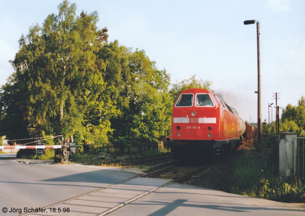 Auma war der einzige grere Ort an der „Oberlandbahn“ zwischen Triptis und Ziegenrck. Am stlichen Bahnhofsende lag ein handbedienter Bahnbergang fr die Strae nach Triptis. 219 151 passierte ihn mit einem Gterzug nach Triptis am 18.5.98.