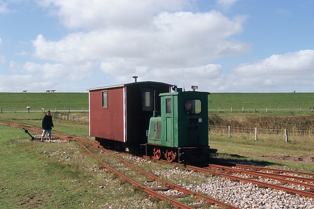 Aus dem Dia-Archiv: 
Halligbahn Lttmoorsiel - Nordstrandischmoor / Lok Nr.2 (Schma CDL10, Bj. 1968, Serien-Nr. 3105) mit Wagen 2 am 08.09.2006 vor dem Bh Lttmoorsiel. 
Die Fahrzeuge gehrten damals zum ALR (Amt fr lndliche Rume) heute LKN S-H (Landesbetrieb fr Kstenschutz, Nationalpark und Meeresschutz Schleswig-Holstein), dem Betreiber dieser Lorenbahn. 