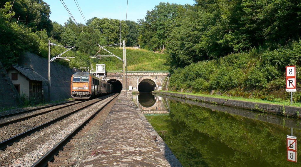 Aus dem westlichen Tunnelausgang in Arzviller, der parallel zum Rhein-Marne-Kanal liegt, kommt die SNCF BB26146 mit dem Zug TER96248 (Basel-Straburg-Nancy).

15.07.2011 Arzviller