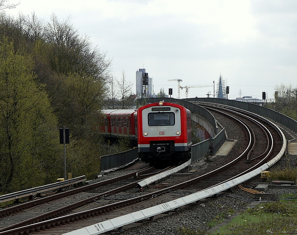 Aus der Kurve der  Verbindungsbahn  nhert sich ein Zug der S21 dem Bahnhof  Diebsteich . Alle Zge mit zweistelliger Liniennummer fahren auf der alten Stammstrecke ber Dammtor, die anderen auf der unterirdischen  City-Bahn . Rechts im Bild die Rampe fr diese von Altona kommenden Zge. Hamburg, 27.4.2013