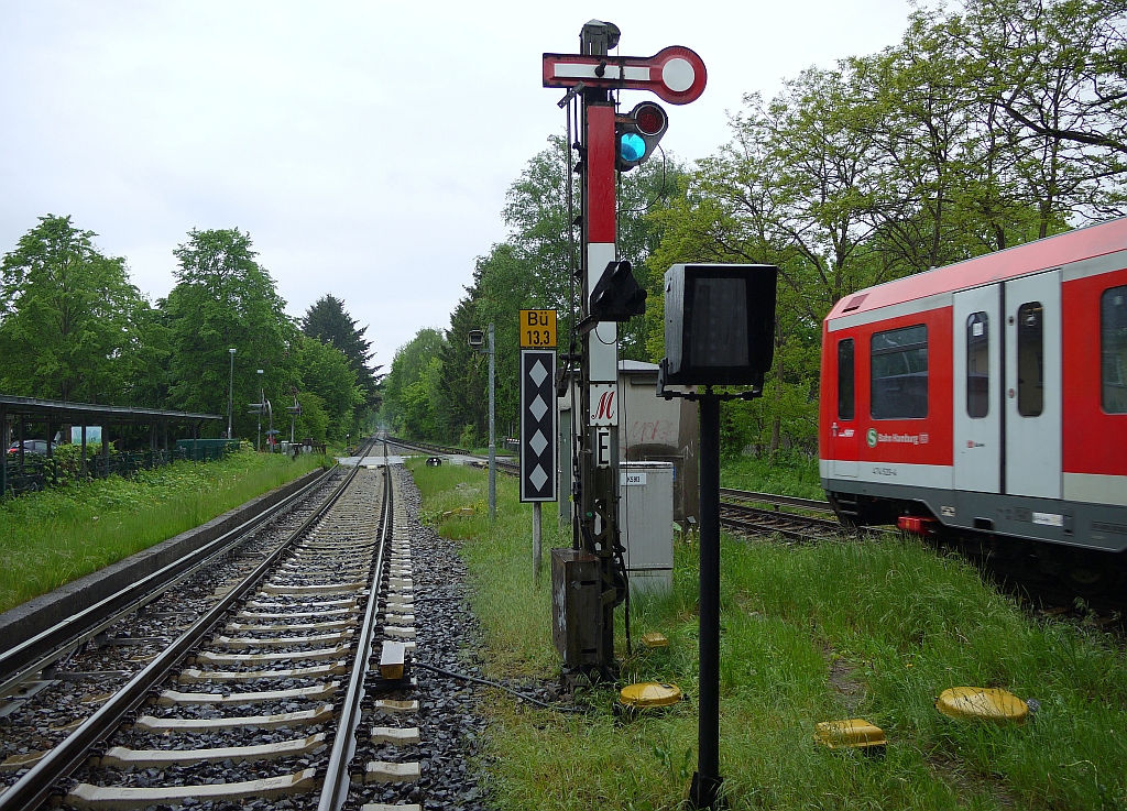 Ausfahrt eines Zuges der Hamburger S-Bahn aus der Station  Slldorf . Skurril: wegen der schlechten Sicht durch den berdachten Fugngerweg wurde eines der Ausfahrtsignale Richtung Westen in Hhe und Breite gestutzt. 26.5.2013 