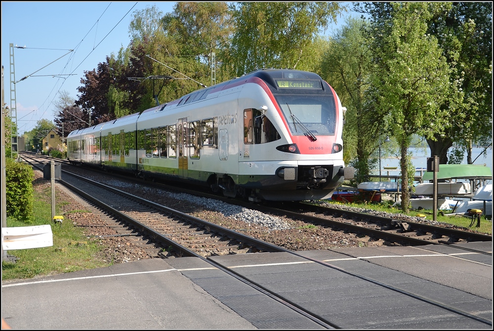 Badische Hauptbahn, die letzten Kilometer (VI). Ein wenig mehr Ortsbezug, hinter dem Seehasen 526 656-0 lugt der Gnadensee hervor. Allensbach, April 2011.