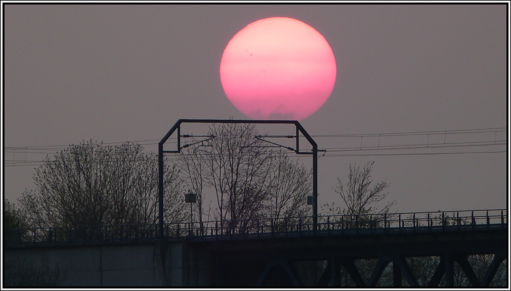 Bahnbild Nr.375,als Stimmungsfoto eingefangen in Moresnet(Belgien),Anfang Mai 2013.
Dieser Oberleitungsmast mit eigener Beleuchtung,(nur kurzzeitig verf�gbar).
Unser W�rmespender mal ganz fett am belgischen Abendhimmel. Mal schauen welche �berraschungen die Sonne 2013 parat hat. Gut zu erkennen die 4 gro�en Sonnenflecken.