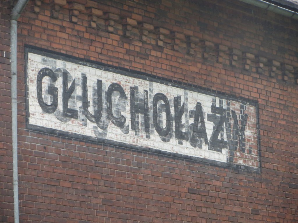 Bahnhof Bad Ziegenhals (Glucholazy) auf polnischem Gebiet. Der Bahnhof wird nur von Zgen der tschechischen Strecke Jgerndorf (Krnov) - Freiwaldau (Jesenik) angefahren. Aufnahme vom 14. Juli 2013. Unter dem zwei Mal aufgetragenen Glucholazy lsst sich noch Ziegenhals lesen.