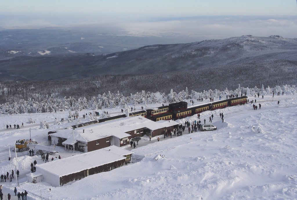 Bahnhof Brocken am Nachmittag des 26.01 2013. Vorn auf Gleis 1 steht P8922, welcher nach Umsetzen der Lok, in wenigen Minuten nach Drei Annen Hohne starten wird. Der Zug auf Gleis 2 ist der  Quedlinburger Brockenexpress  mit 99 7245 an der Spitze. Dieser wird einige Zeit sp�ter nach Wernigerode fahren. Die Aufnahme entstand von der Aussichtsplattform des Brockenturms aus (durch die Scheibe!) In diesem Turm befindet sich au�erdem das Brockenhotel und ein gem�tliches Cafe mit toller Aussicht!