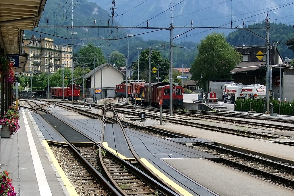 Bahnhof Meiringen 2005. In Verlngerung des Gleises Richtung weie Hauswand, dort wo der Traktor Tm 598 und der Montagewagen X 9757 stehen, fahren heute die Zge der MIB ab. Frher war die Haltestelle der MIB (Meiringen Innertkirchen Bahn) hinter dem Bahnbergang an dem wei/blauem Schild. Das linke Bahnareal mit den 3 Traktoren und der Drehscheibe ist heute ein Parkplatz. (23.07.2005)